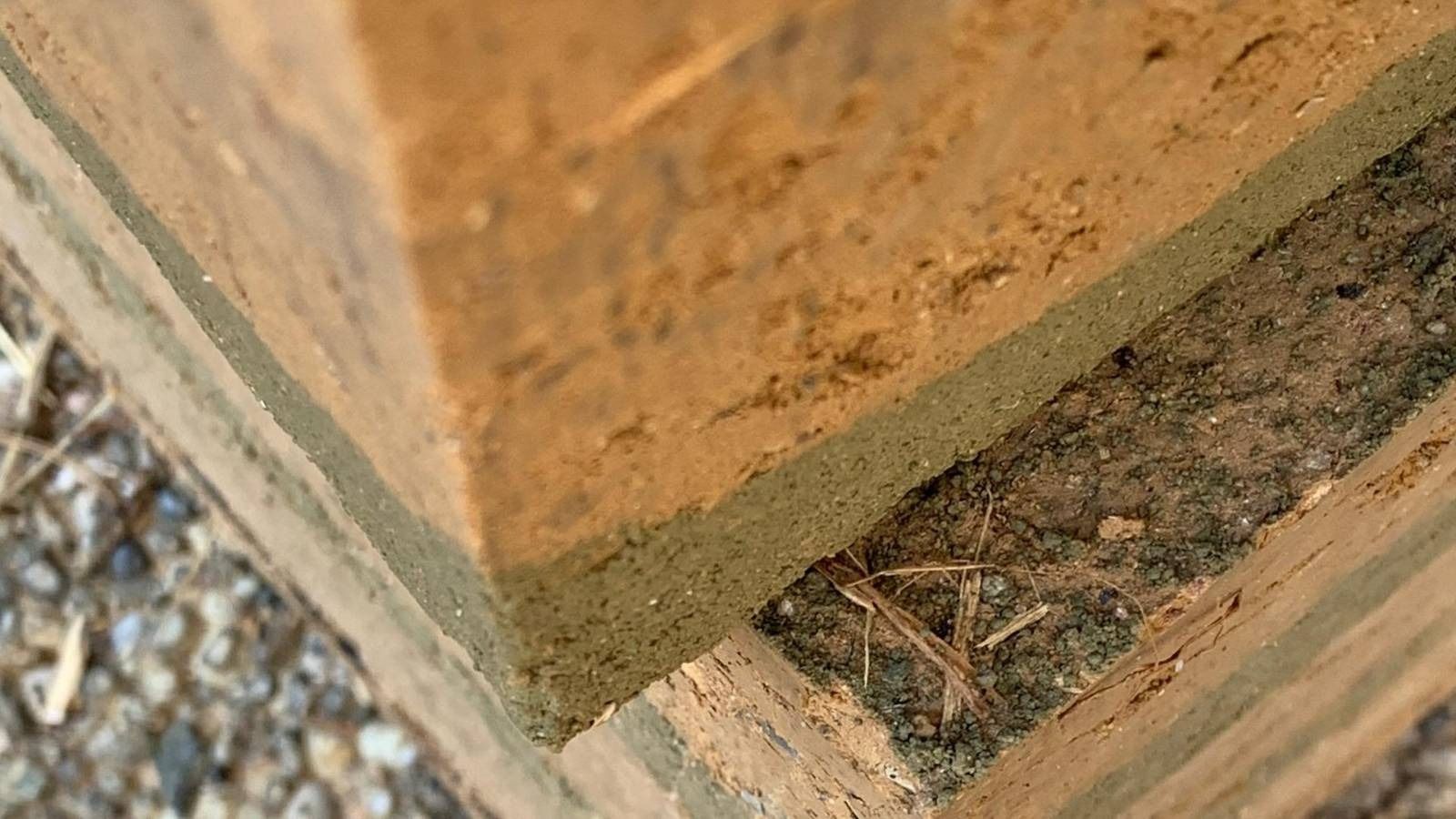 Zoomed in perspective on clay bricks. The different layers of compressed soil are visible in their different shades of brown.